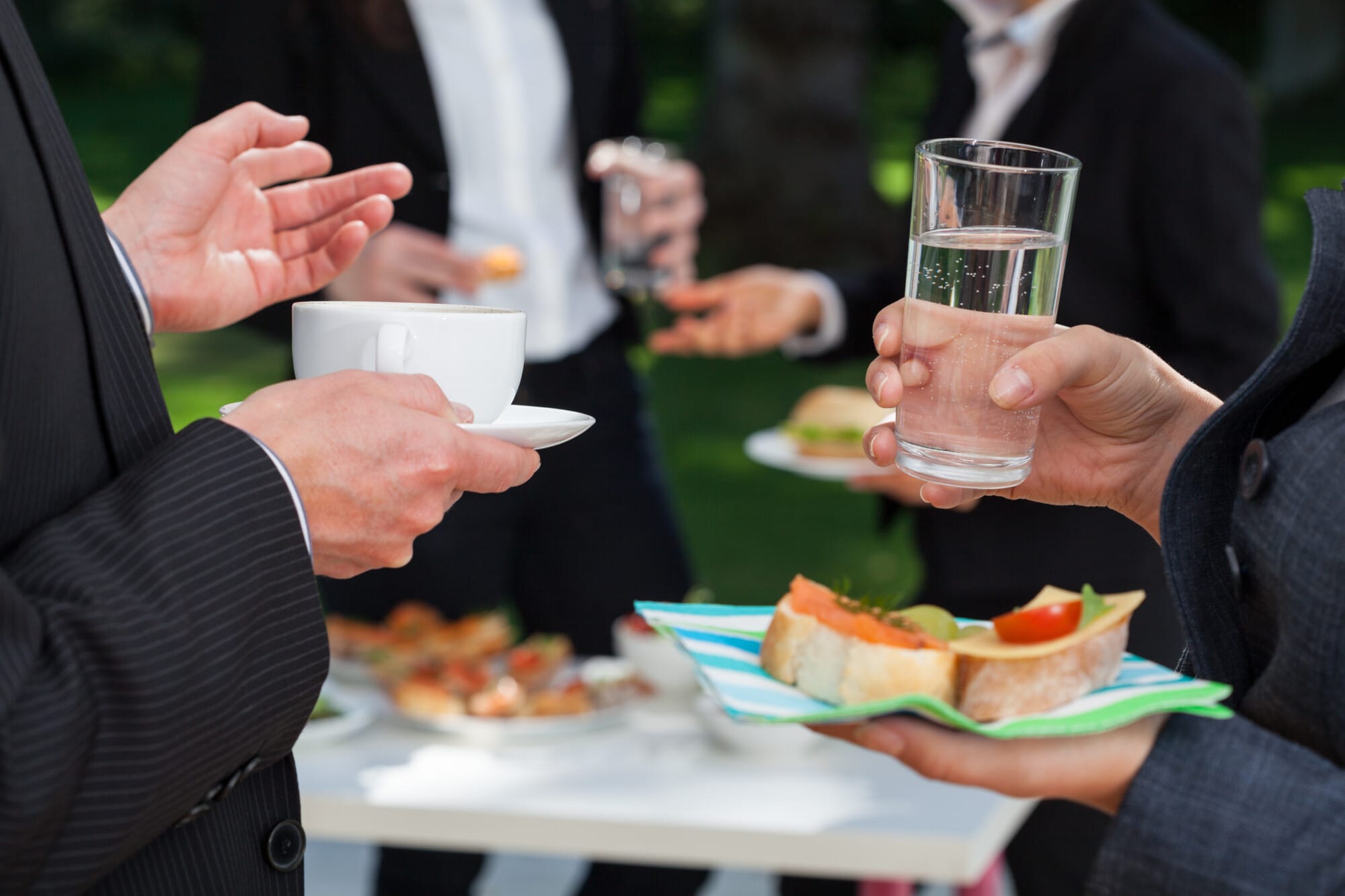 People holding drinks and appetizers